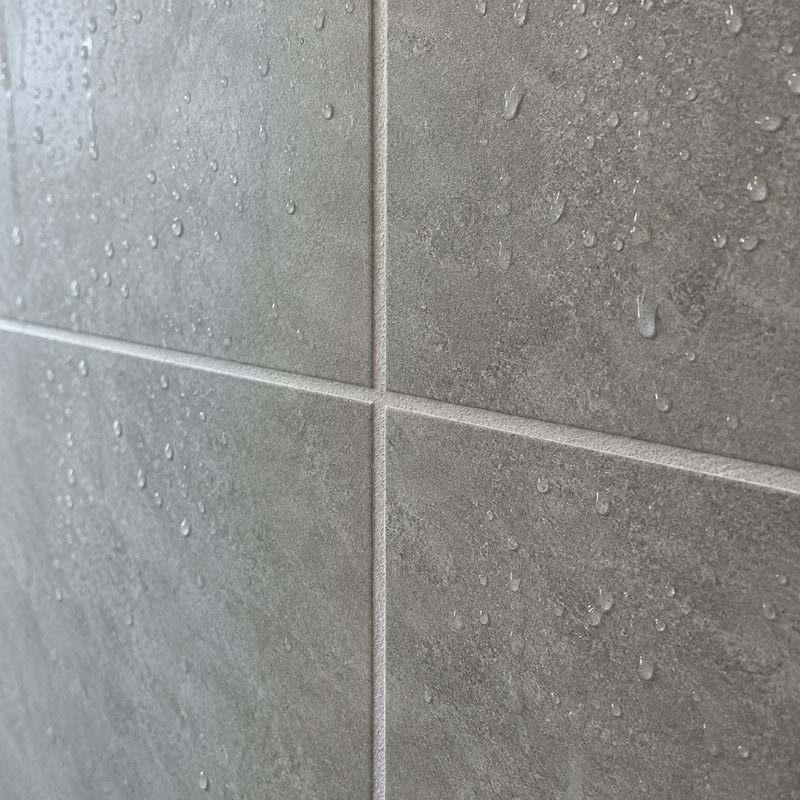 Detalje af ny vådrumsmembran og friske flisefuger i et bad under renovering